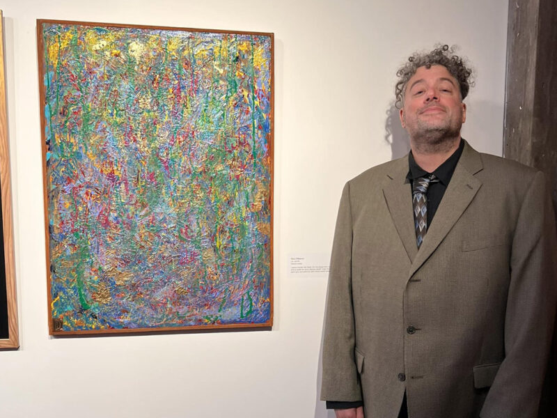 a-man-standing-in-front-of-a-painting a man standing in front of a painting